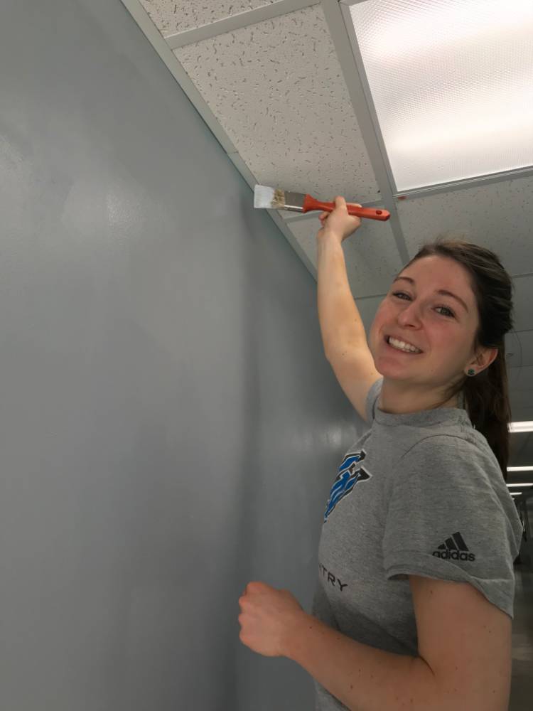 Volunteer painting the wall.